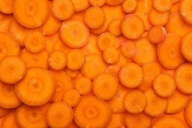 Photo of Slices of fresh raw carrots as background, top view