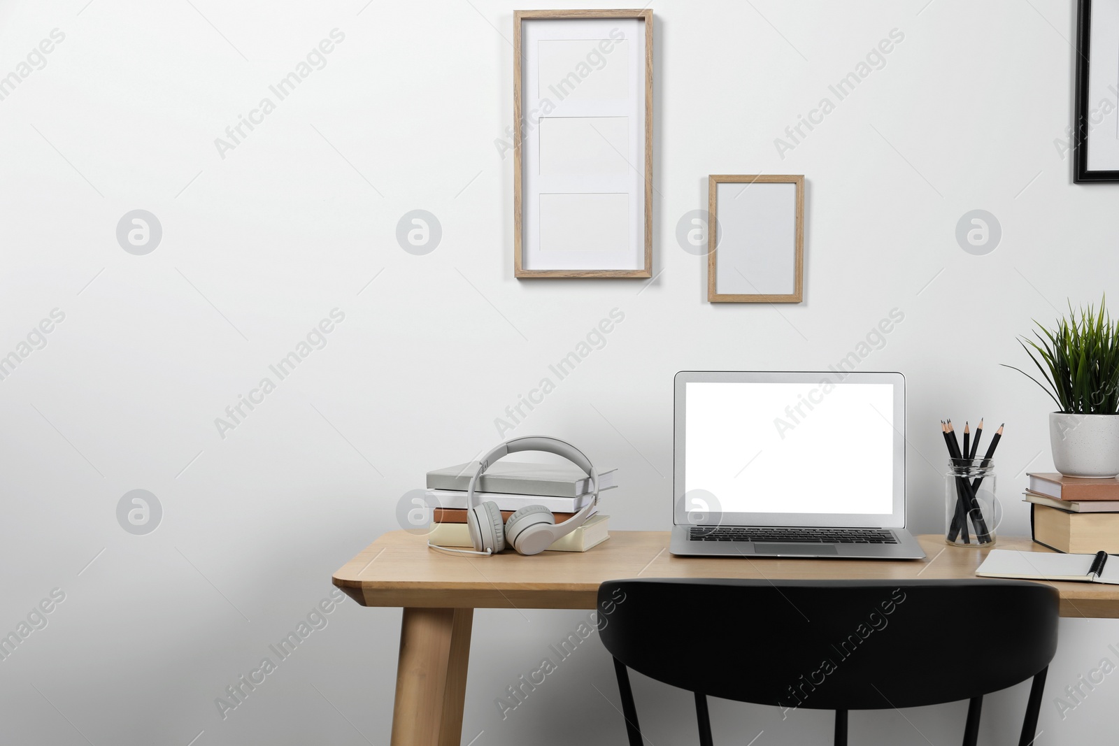 Photo of Cozy workspace with laptop and stationery on wooden desk at home