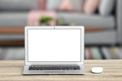 Photo of Laptop with blank screen on table indoors. Space for text