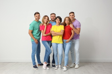 Group of young people near light wall. Unity concept