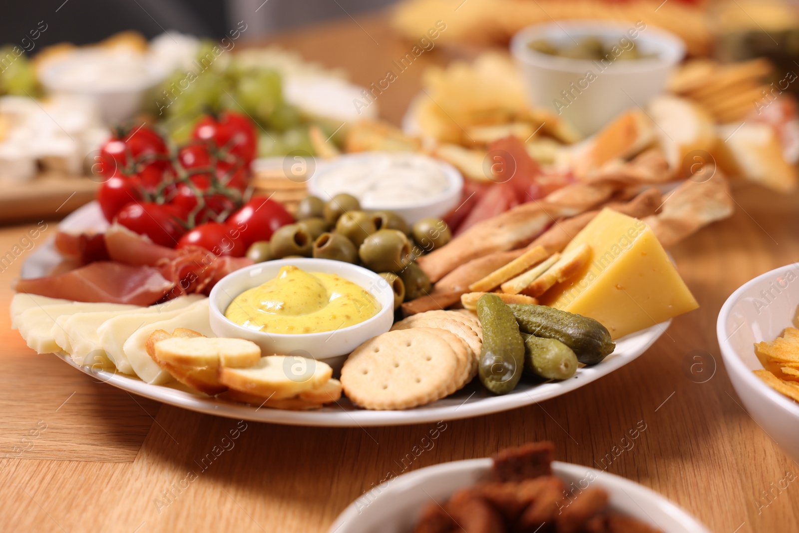 Photo of Assorted appetizers served on wooden table, closeup