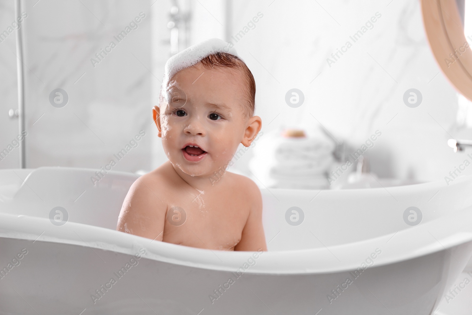 Photo of Cute little baby in bathtub at home