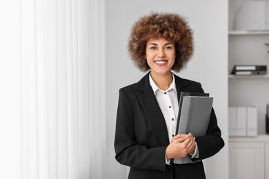 Photo of Happy notary with folders in office, space for text