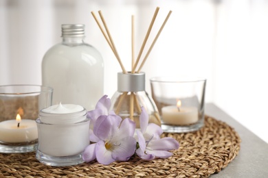 Photo of Composition with skin care products and reed air freshener on light background