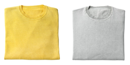 Image of Folded grey and yellow sweaters on white background, top view