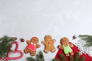 Photo of Flat lay composition with gingerbread people on light  grey marble table. Space for text