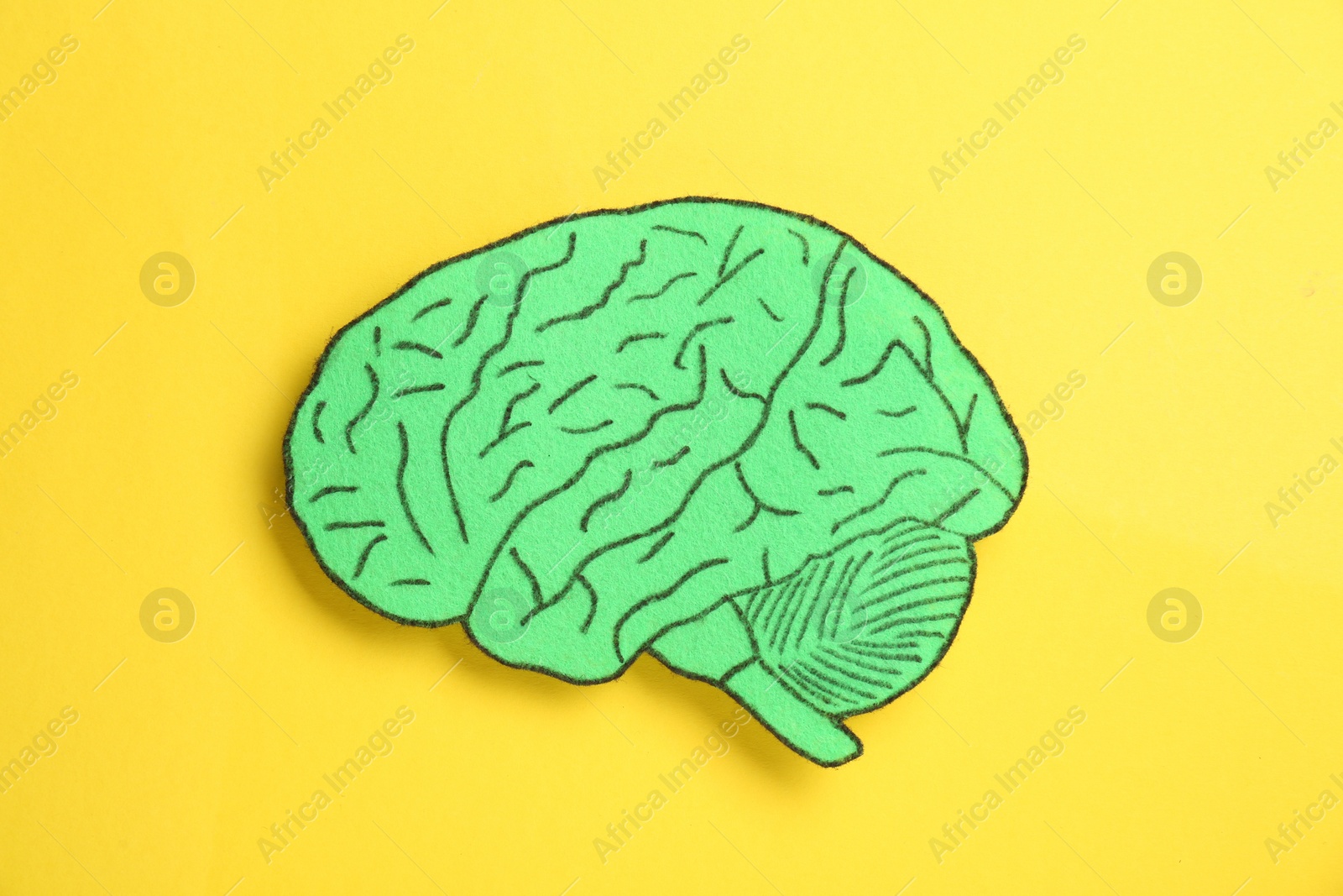 Photo of Paper cutout of human brain on yellow background, top view