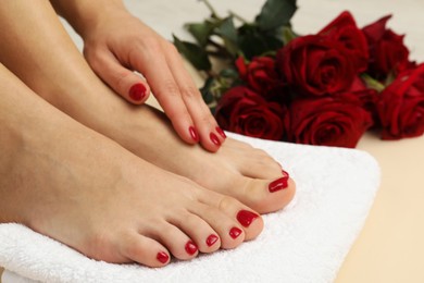 Photo of Woman with stylish red toenails after pedicure procedure on beige floor, closeup