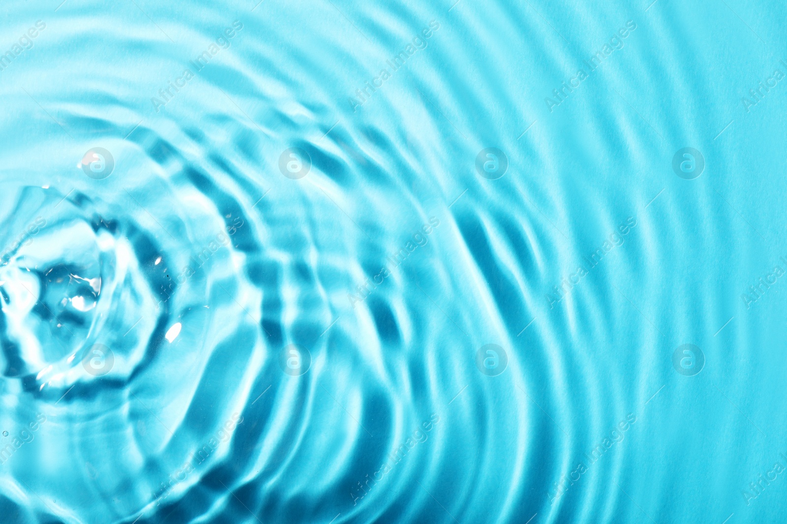 Photo of Closeup view of water with rippled surface on light blue background