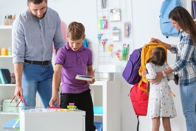 Photo of Children with parents choosing school stationery in store