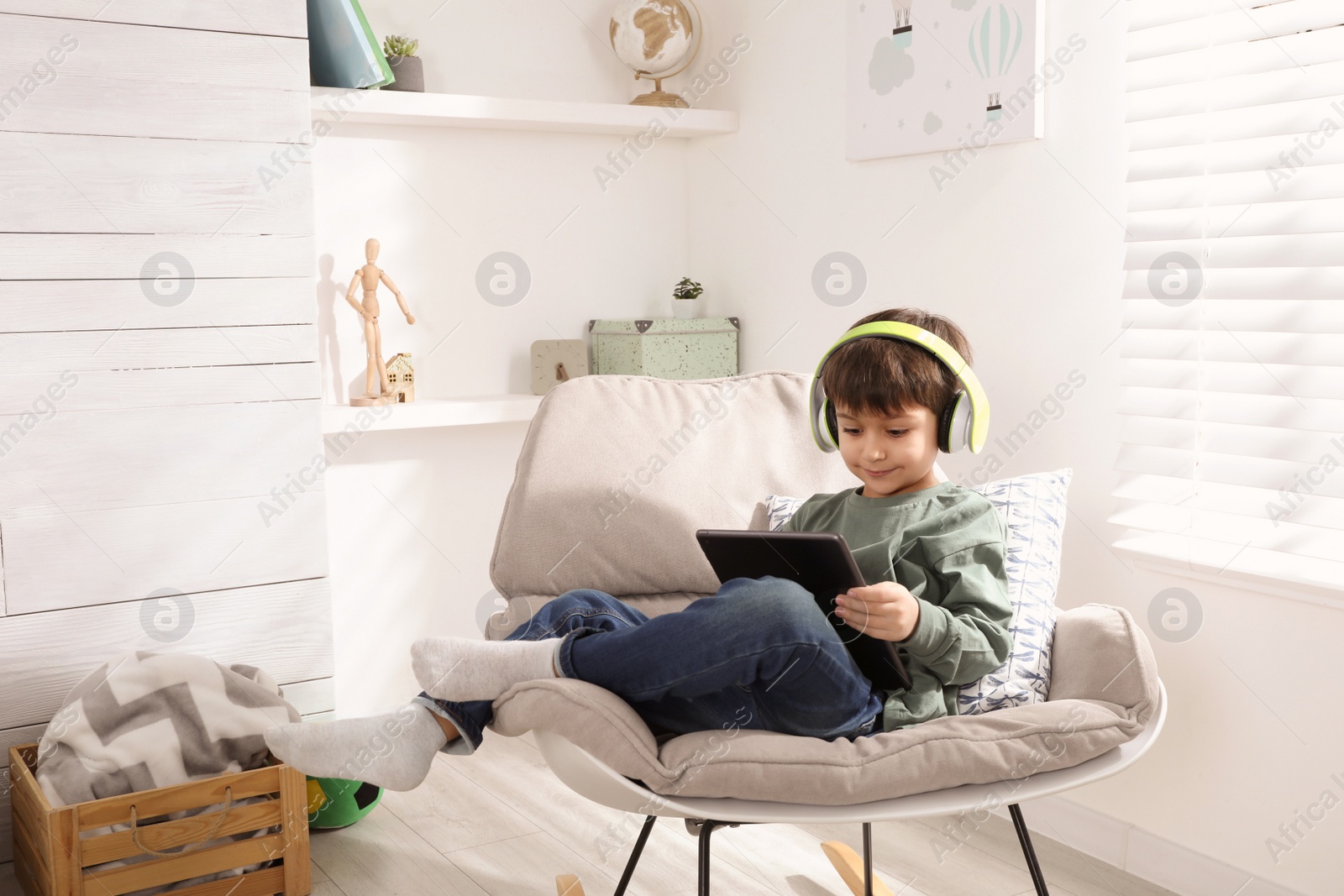 Photo of Cute little boy with modern tablet studying online at home. E-learning