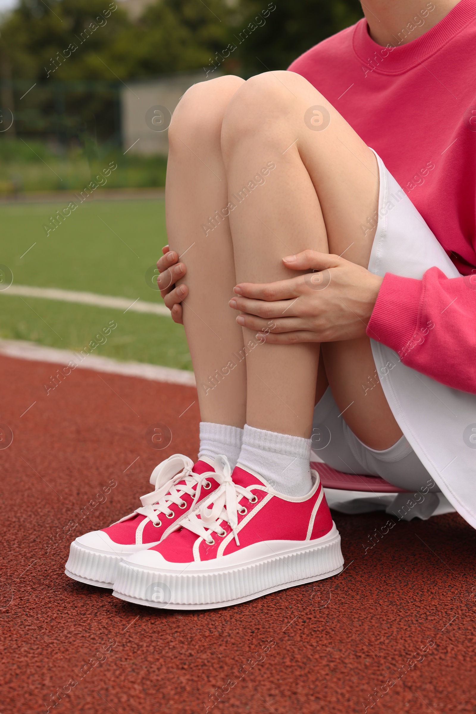 Photo of Woman wearing classic old school sneakers on sport court outdoors, closeup