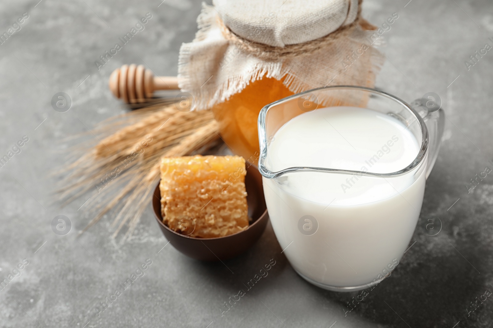 Photo of Beautiful composition with milk and honey on grey background