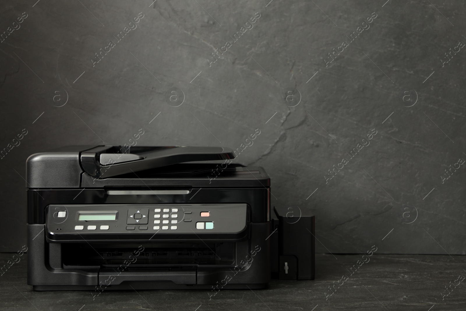 Photo of New modern printer on black background. Space for text