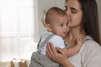 Photo of Happy young mother with her baby at home. Space for text