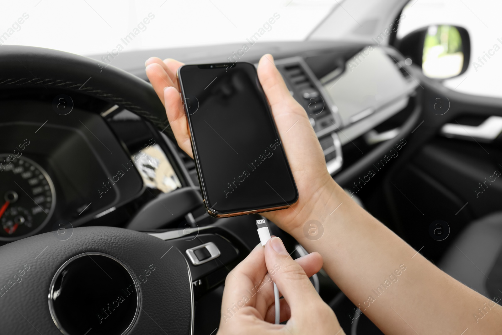 Photo of Person charging phone with USB cable in car