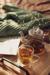 Photo of Wooden tray with freshly brewed tea on bed in room. Cozy home atmosphere