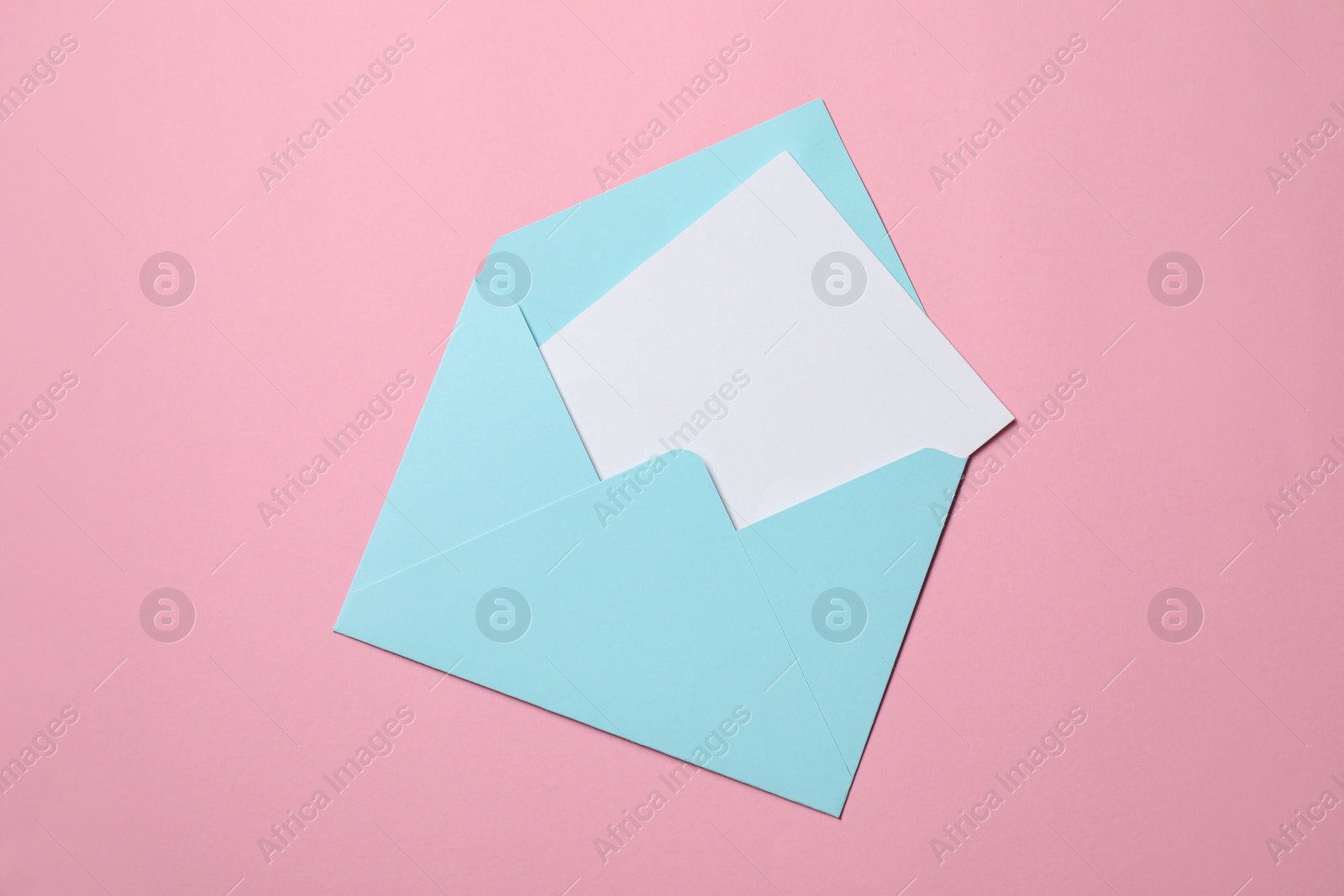 Photo of Letter envelope with card on pink background, top view