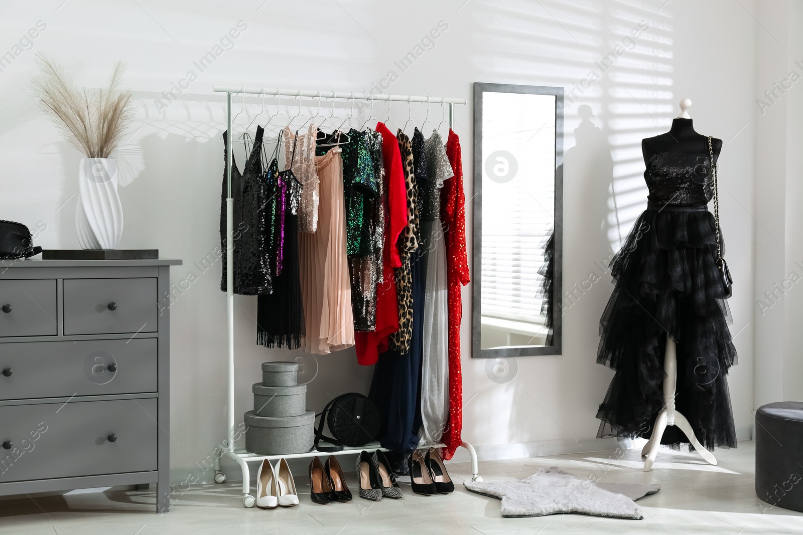 Photo of Rack with collection of beautiful festive clothes in stylish room interior