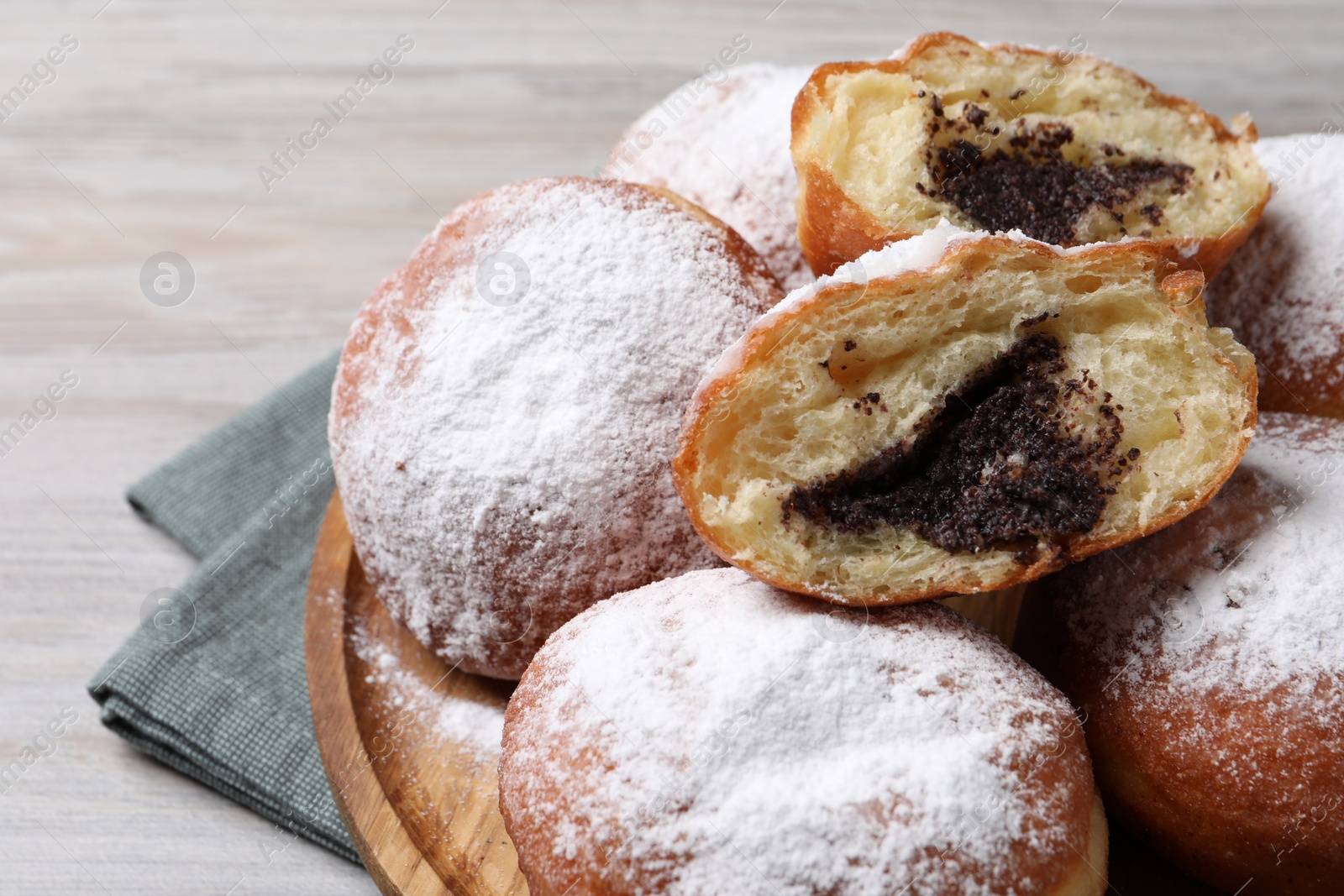 Photo of Delicious sweet buns with poppy seeds on light wooden table, closeup