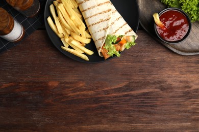 Delicious chicken shawarma and French fries served on wooden table, flat lay. Space for text