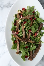 Photo of Delicious salad with beef tongue, arugula and seeds on white marble table, top view