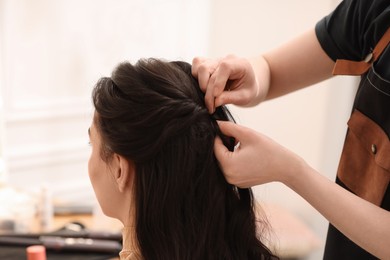 Photo of Hair styling. Professional hairdresser working with client indoors, closeup