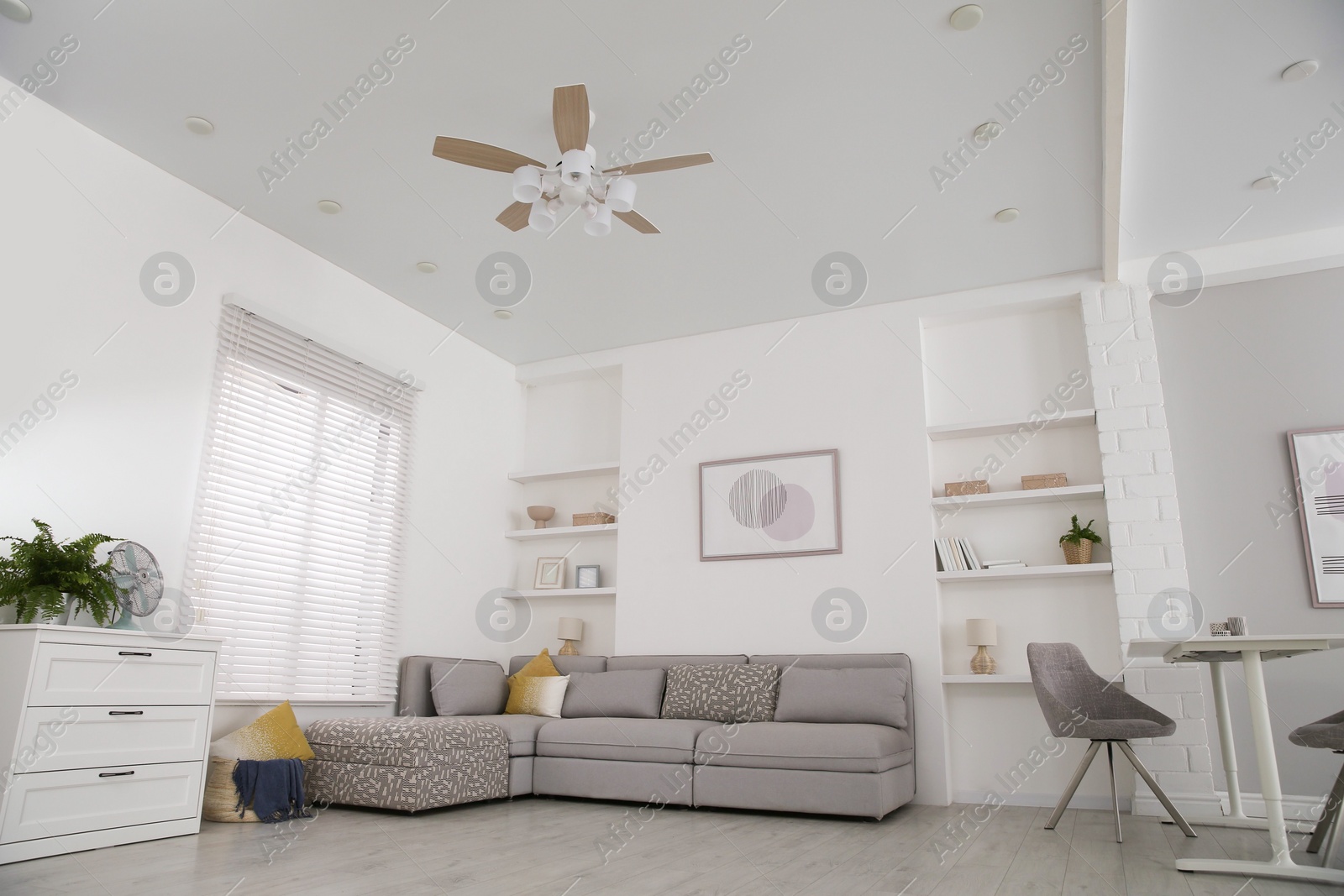 Photo of Comfortable furniture, ceiling fan and accessories in stylish living room