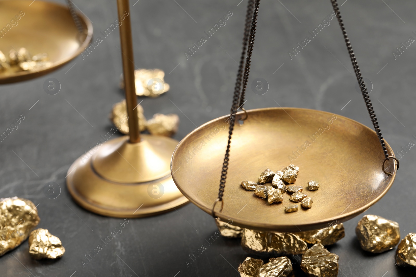 Photo of Vintage scales with gold nuggets on black marble table