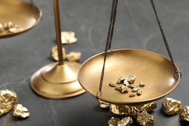 Vintage scales with gold nuggets on black marble table