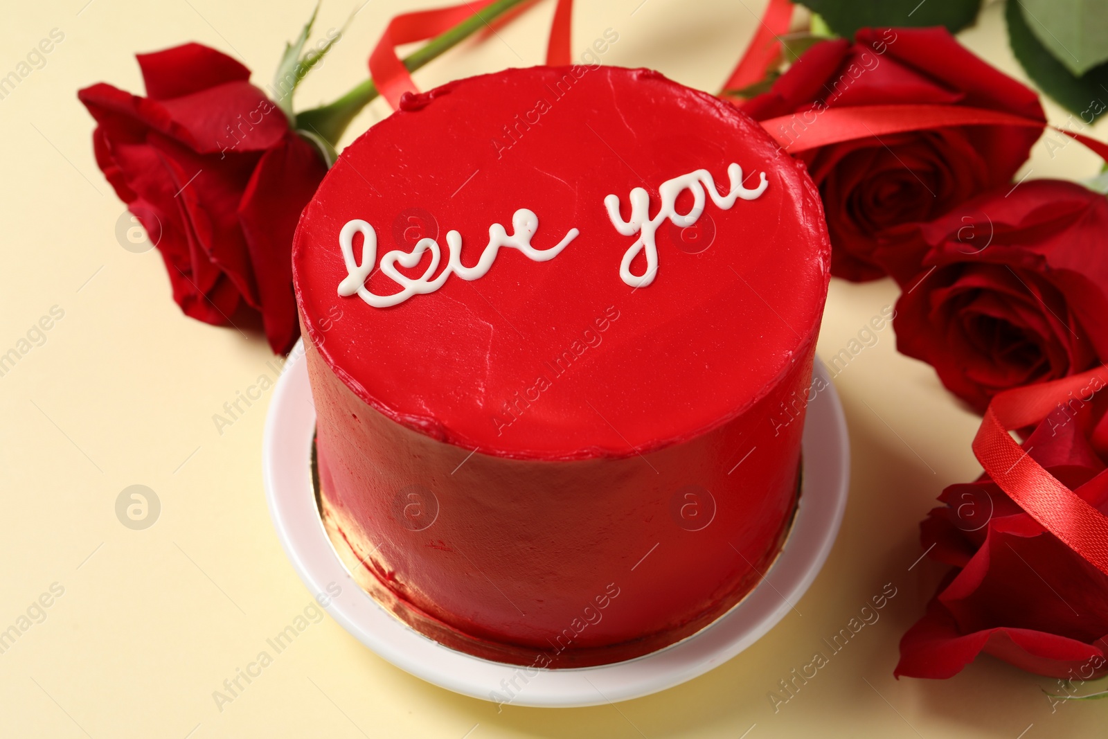 Photo of Bento cake with text Love You and red roses on beige table, closeup. St. Valentine's day surprise