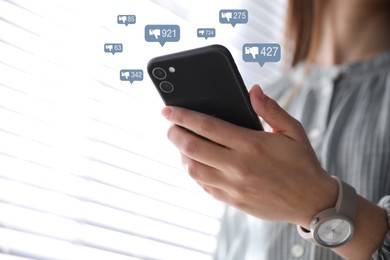 Image of Closeup view of young woman using modern smartphone indoors and virtual dislike icons. Cyberbullying concept