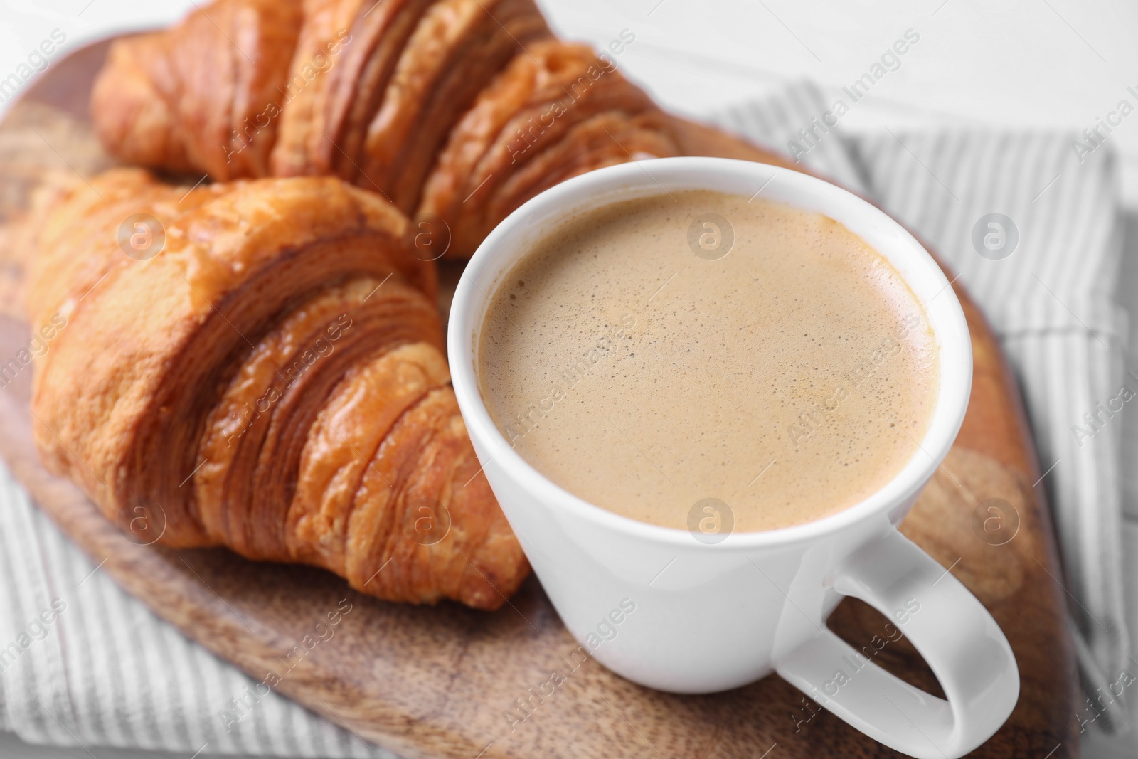 Photo of Tasty breakfast. Cup of coffee and croissants on table, closeup