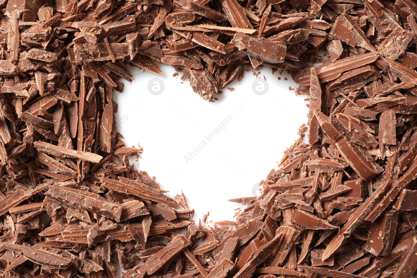 Photo of Heart made with milk chocolate crumbles on white background, top view