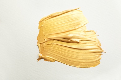 Photo of Golden paint brush strokes on white background