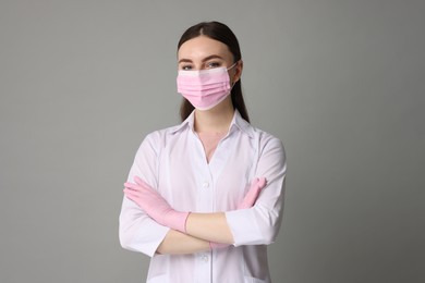 Cosmetologist in medical uniform on grey background