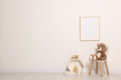 Beautiful children's room with light wall, furniture and toys, space for text. Interior design