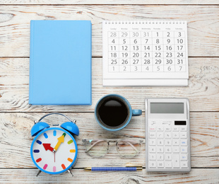 Flat lay composition with calendar and cup of coffee on white wooden table