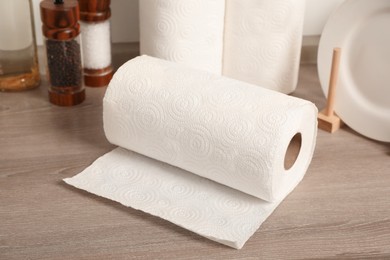 Photo of Rolls of white paper towels and other kitchen stuff on wooden countertop