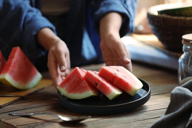 Photo of Woman taking plate with slices of fresh watermelon, closeup