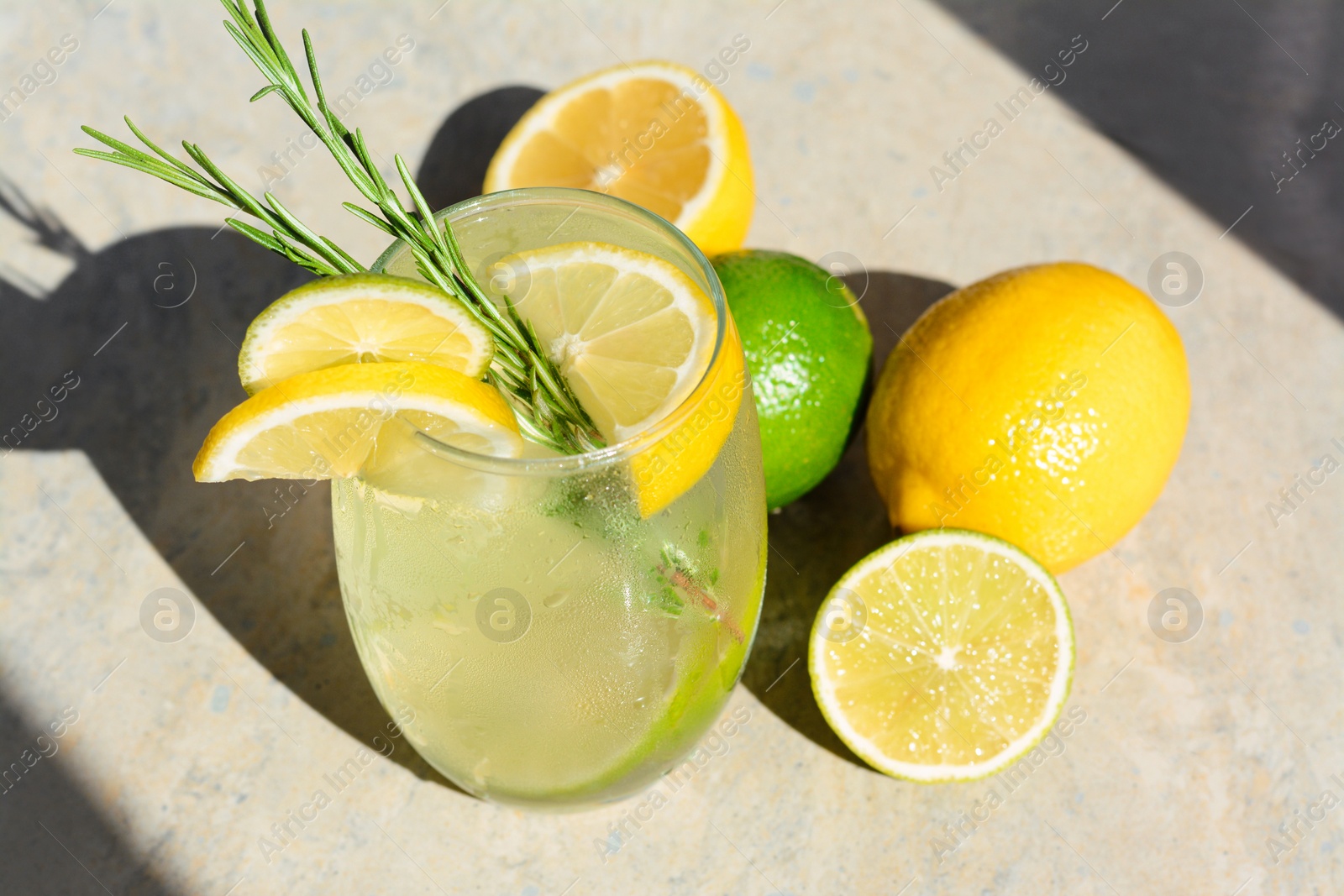 Photo of Tasty refreshing lemonade and ingredients on light table. Summer drink