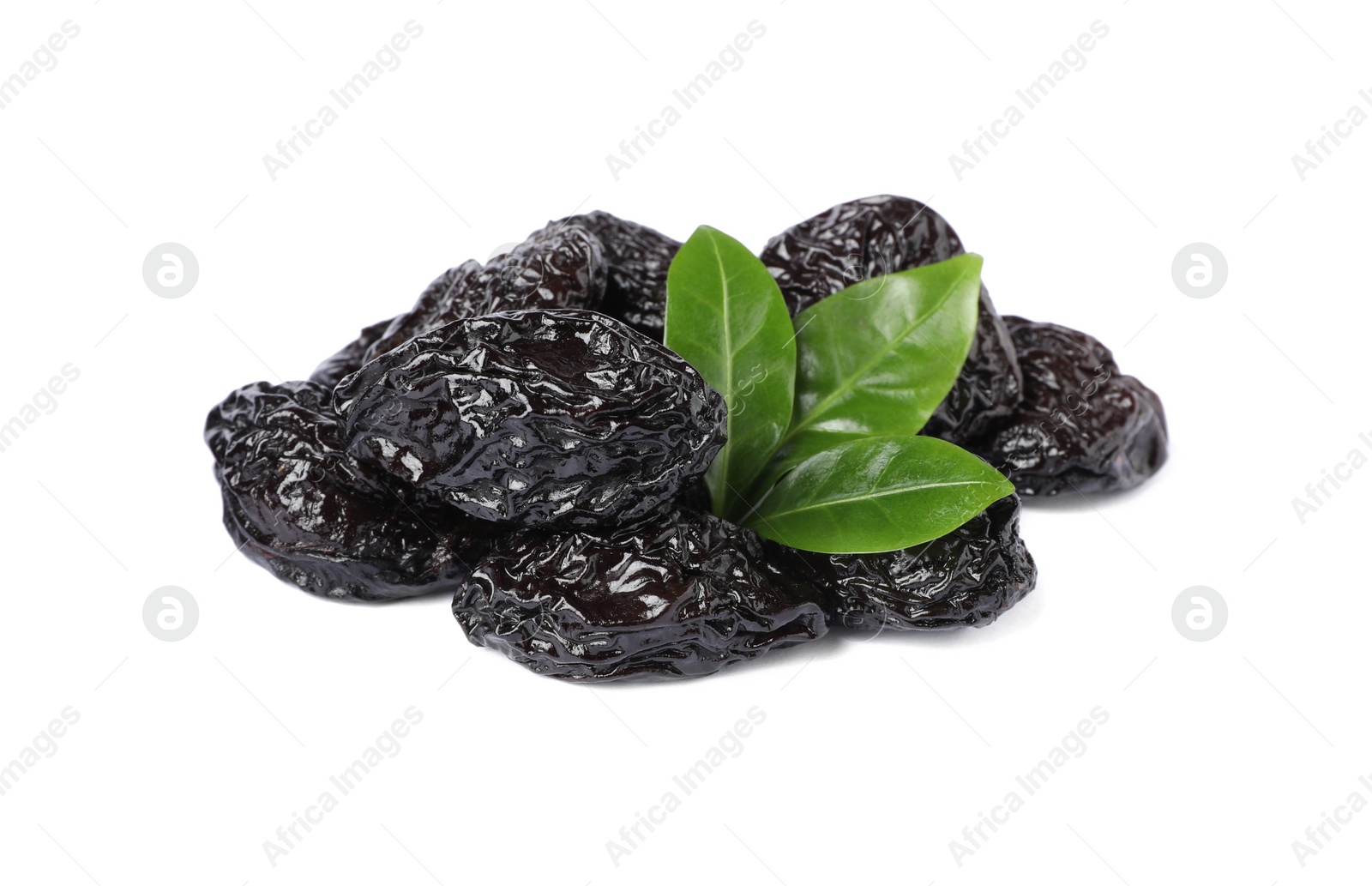 Photo of Heap of sweet dried prunes and green leaves on white background