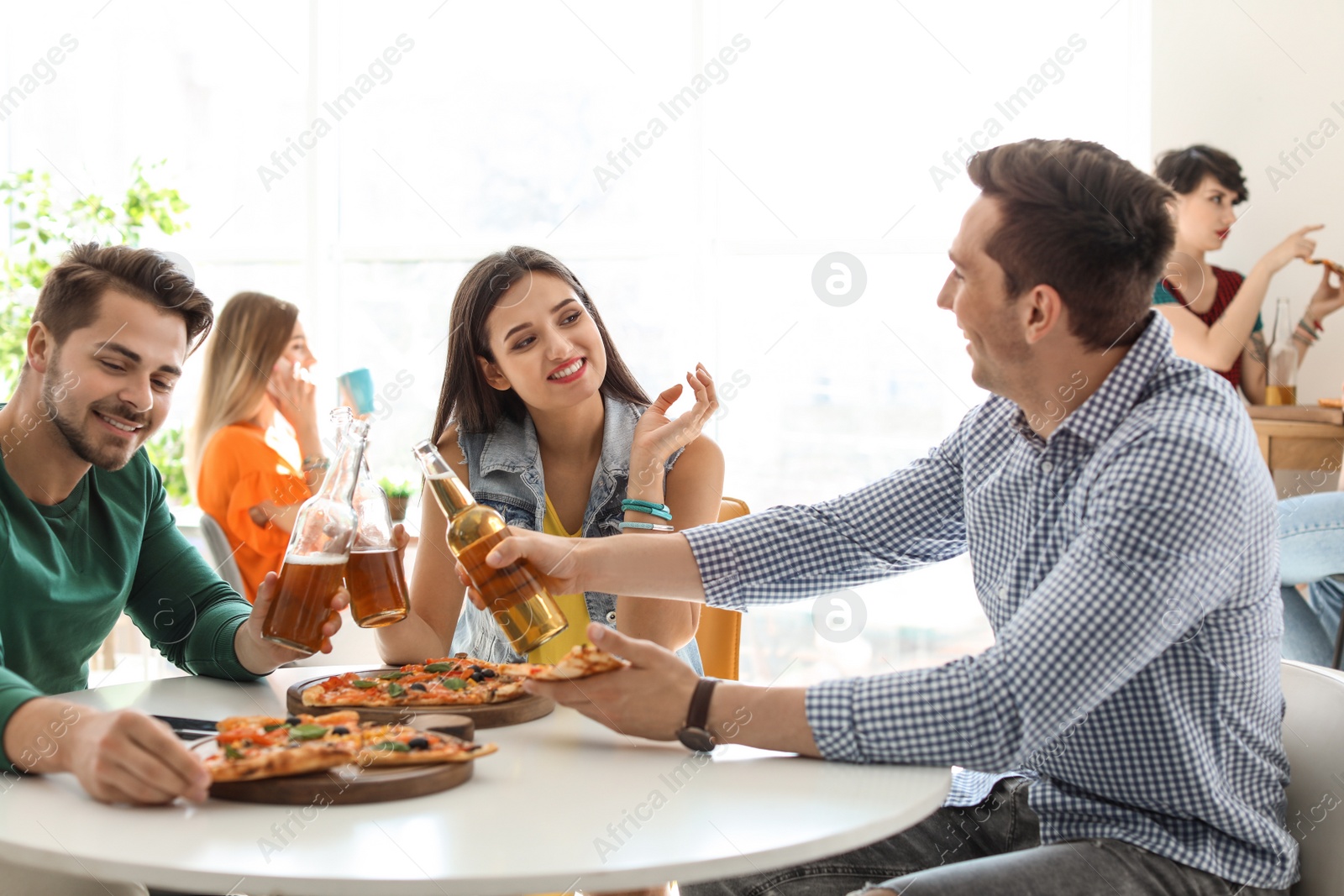 Photo of Young people having fun party with delicious pizza indoors