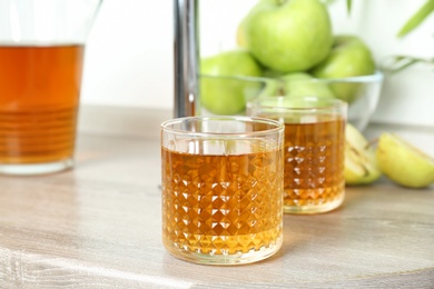 Glasses of apple juice on wooden table