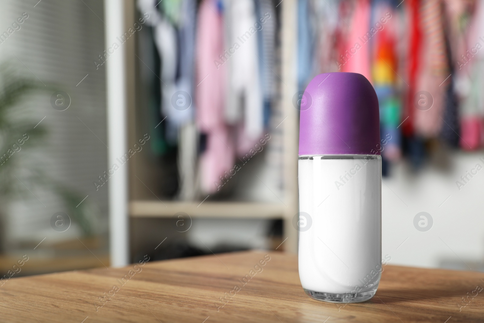 Photo of Natural female roll-on deodorant on wooden table indoors. Space for text