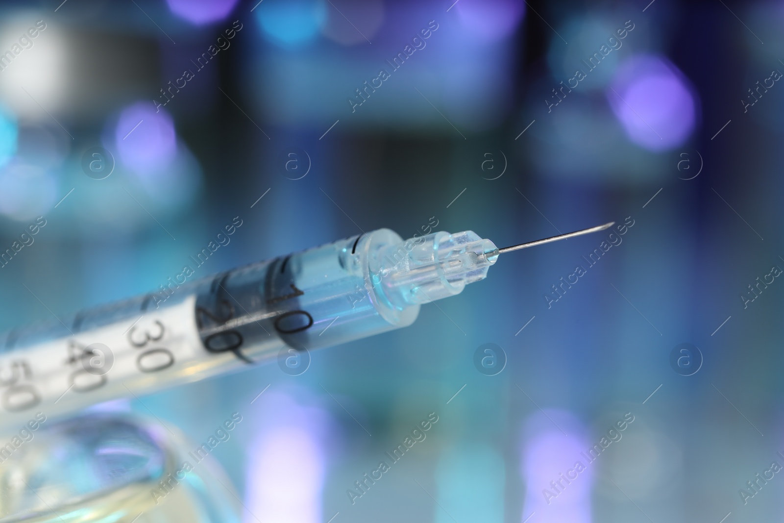 Photo of Syringe with medicine against blurred background, closeup