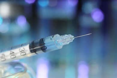 Photo of Syringe with medicine against blurred background, closeup