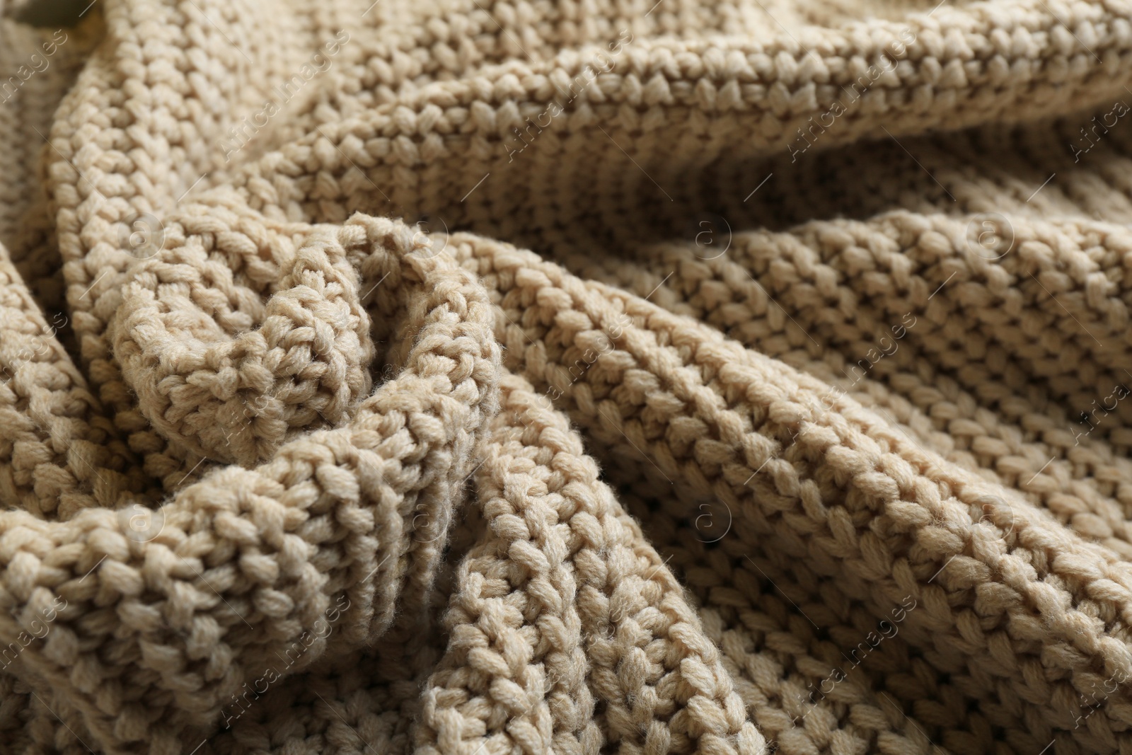 Photo of Beautiful beige knitted fabric as background, closeup