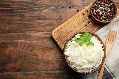 Tasty fermented cabbage on wooden table, flat lay