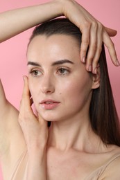 Portrait of beautiful young woman on pink background